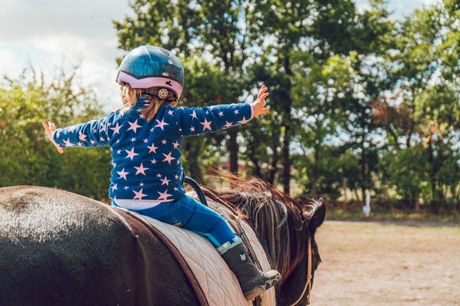 Lorsqu'il apprend à monter à cheval, l'enfant exerce son équilibre en selle.